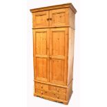 A large contemporary pine two door wardrobe with twin door cupboard section to the top and three