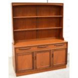 A retro G Plan teak dresser with plate rack above three drawers and cupboards, width 145cm.