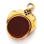 A 9ct gold fob with carnelian stone set in a scrolling mount, approx 5.4g.