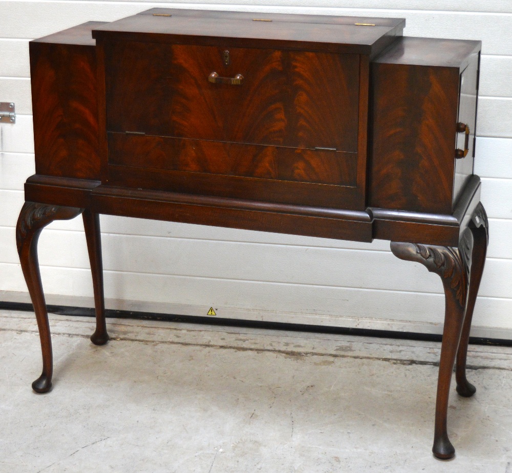 A 20th century flame mahogany cocktail cabinet with integral accessories for making cocktails to