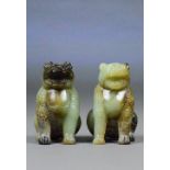 A pair of Chinese jade and included carved models of seated leopards,