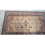 A vintage Pakistani cream and terracotta ground rug with geometric border and a symbolic design to