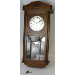 An early 20th century oak cased 30 hour wall clock, silvered dial set with Arabic numerals,