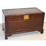 An Oriental hardwood chest on bracket feet with large brass fastening, 65 x 99cm.