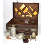A vintage leather travelling case with moire silk lining, various cosmetic bottles, hairbrushes,