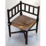 A late 19th century rush seated bobbin turned corner chair in need of repair.