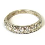 An 18ct white gold eternity ring set with seven round brilliant cut diamonds with bark finish shank,
