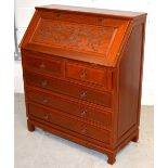 A 20th century Oriental hardwood bureau with fall front desk top carved with an Oriental scene of