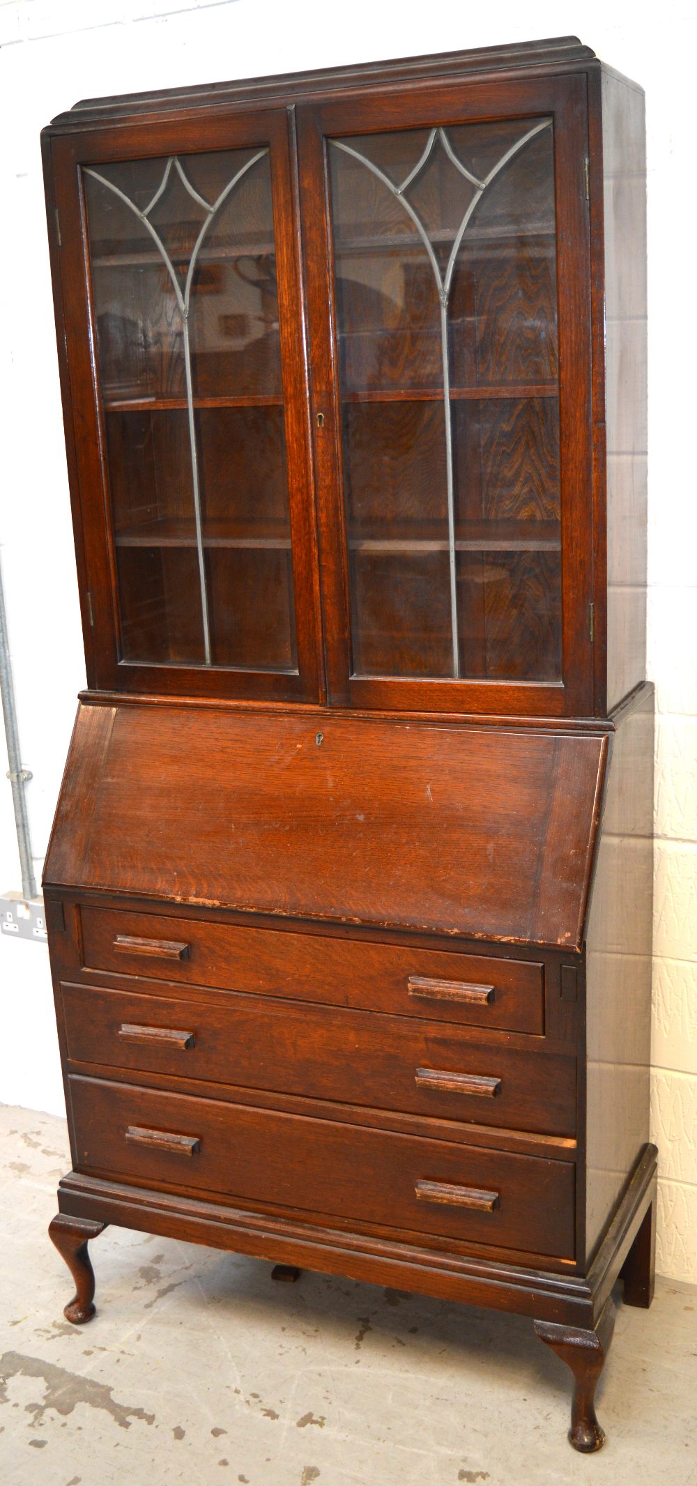 A 20th century oak bureau bookcase, two glazed doors above fitted interior to front cabriole legs,