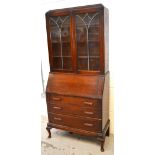 A 20th century oak bureau bookcase, two glazed doors above fitted interior to front cabriole legs,