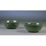 A pair of Chinese spinach jade bowls with etched decoration of a continuous landscape to the