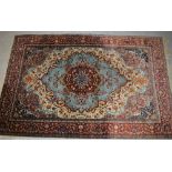 An Oriental red and aqua ground rug with floral design to the centre and floral border on deep red