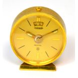 A Jaeger LeCoultre eight day travelling alarm clock, gilt dial set with ebonised and gilt batons,