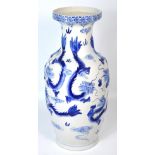 A large 20th century blue and white Oriental baluster vase decorated with dragons and clouds,