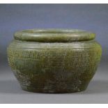 A large Chinese jade bowl with archaic incised decoration throughout and folded rim, diameter 19cm.
