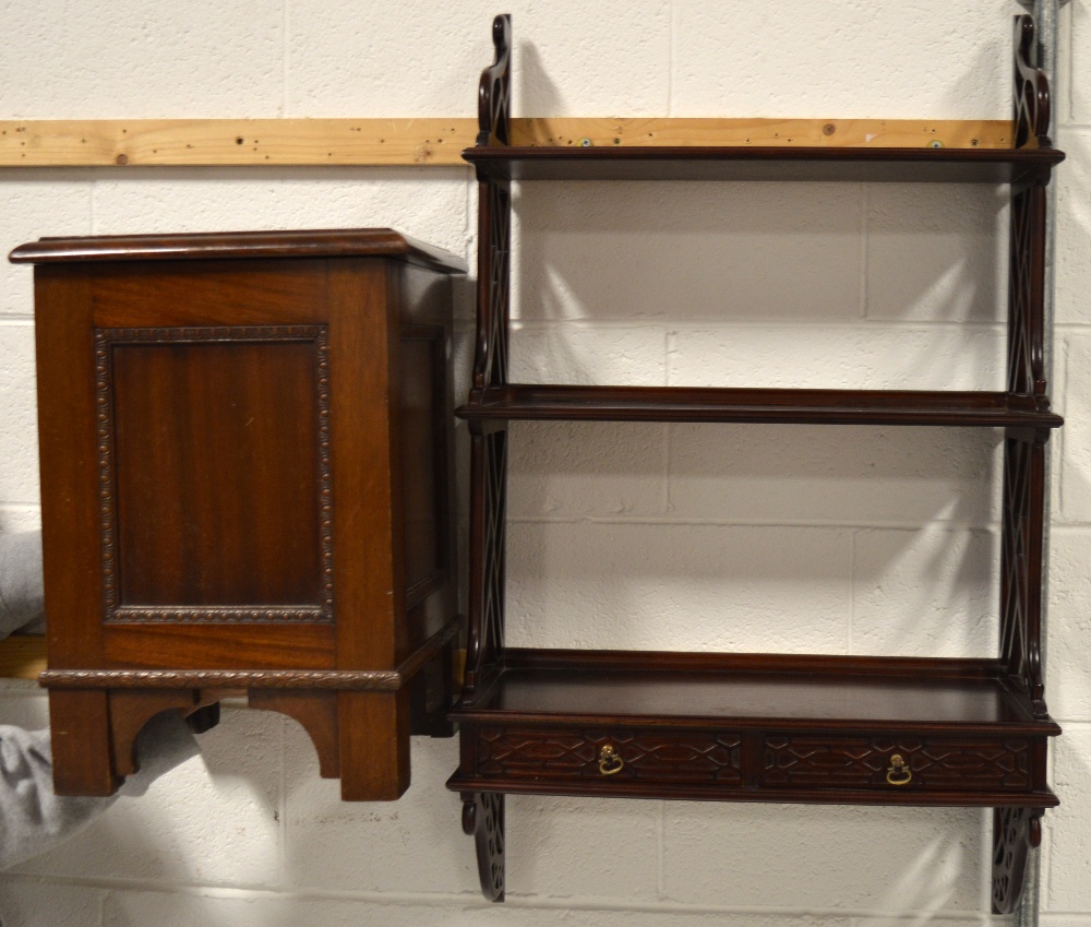 A mahogany Oriental inspired wall mounted book shelf with two lower drawers,