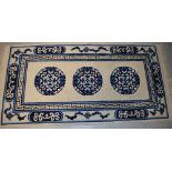 An Oriental cream ground wool rug with Oriental circle design in deep blue and Oriental design