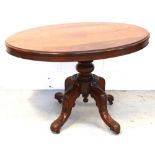 A Victorian mahogany loo table with oval top above foliate carved quadripartite base and castors,
