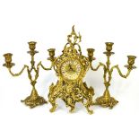 A reproduction ornate heavy brass mantel clock the gilt dial set with Roman numerals on four