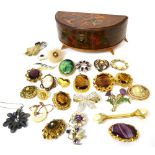 A wooden jewellery box containing a quantity of brooches to include a yellow metal framed cameo