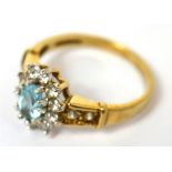 A 9ct gold floral set ring with central blue topaz and white stones, size J, approx 2g.