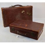 Two vintage leather suitcases.