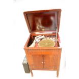 A Gilbert mahogany cased wind up gramophone, and a small quantity of records.