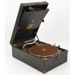 A HMV portable gramophone with a hinged compartment holding records to the interior.