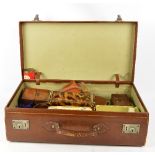 A vintage suitcase containing a small quantity of tins, trinket boxes,