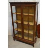 A 20th century display cabinet with two astragal glazed doors on block supports, width 91cm.