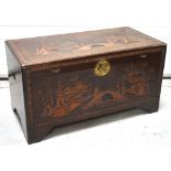 A mid 20th century camphorwood carved chest, the front carved with figures,