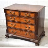 A George III style oak and mahogany crossbanded two over three chest of drawers with quarter column