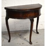 A 19th century oak fold over circular table on three cabriole legs,