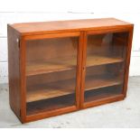 A small teak two door glazed bookcase with interior shelving, width 85cm.