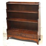 A George III style mahogany bookcase of small proportions with four shelves and two lower drawers,