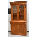 A 20th century pine twin glazed door display cabinet on plinth base, 110 x 210cm.