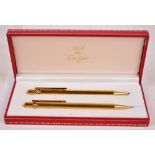 A boxed set of Must de Cartier ballpoint pen and propelling pencil,