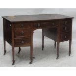 An Edwardian mahogany bowfront seven drawer kneehole desk with leather inset top and square section