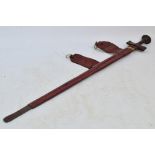 An African Takouba sword with leather grip, tapering blade, and leather scabbard, length 92cm.
