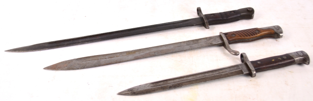 Three WWI period bayonets, all with wooden mounts to the handles, lacking scabbards.