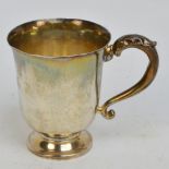 A George V hallmarked silver bell shaped christening mug with leaf capped loop handle,