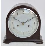 A brown bakelite cased Art Deco mantel clock with silvered dial set with Arabic numerals,