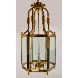 A small hexagonal brass lantern with bevelled plain glass panels and bevelled curved shaped top