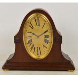 An early 20th century French mahogany cased domed timepiece, the oval dial set with Roman numerals,