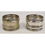 A pair of white metal napkin rings of waisted form with rope decorated rims,