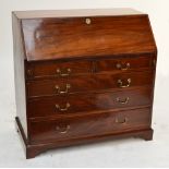 A George III mahogany bureau with fall front enclosing fitted interior above two short and three