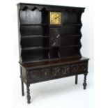 A 1920s oak dresser incorporating an 18th century brass 10" longcase clock dial,