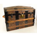 A wooden domed blanket box or travelling trunk with studded metal strapping and further wooden