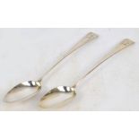 A pair of George III hallmarked silver Old English pattern basting spoons with crested finials,