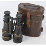 A leather cased pair of WWI military issue field glasses bearing military marks and inscribed "MK V